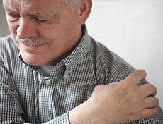 Old man holding his shoulder